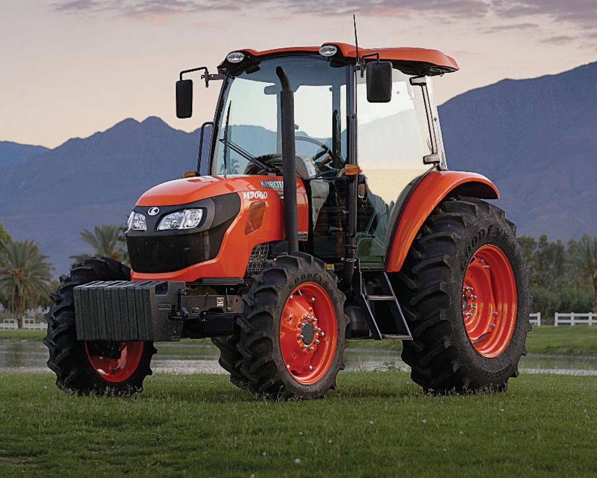 An orange utility tractor in a field